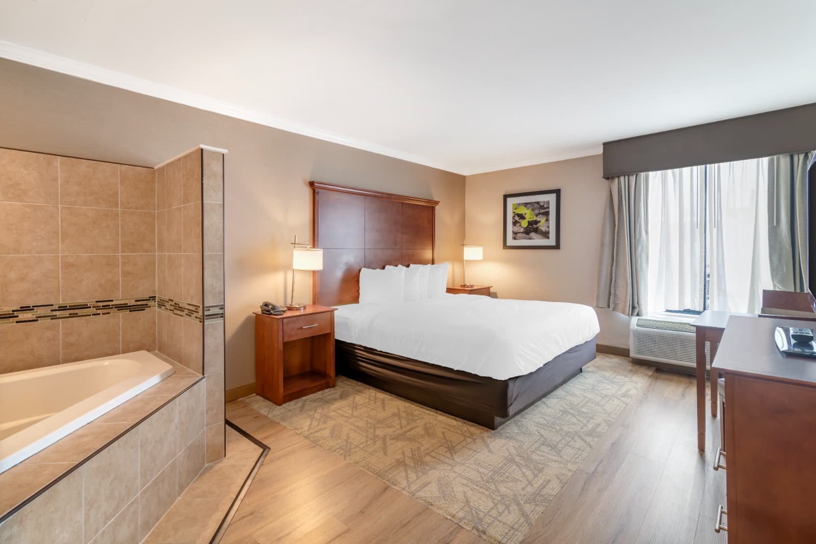 King Jacuzzi room with king bed and in-room two-person jacuzzi tub at Syracuse Grand hotel