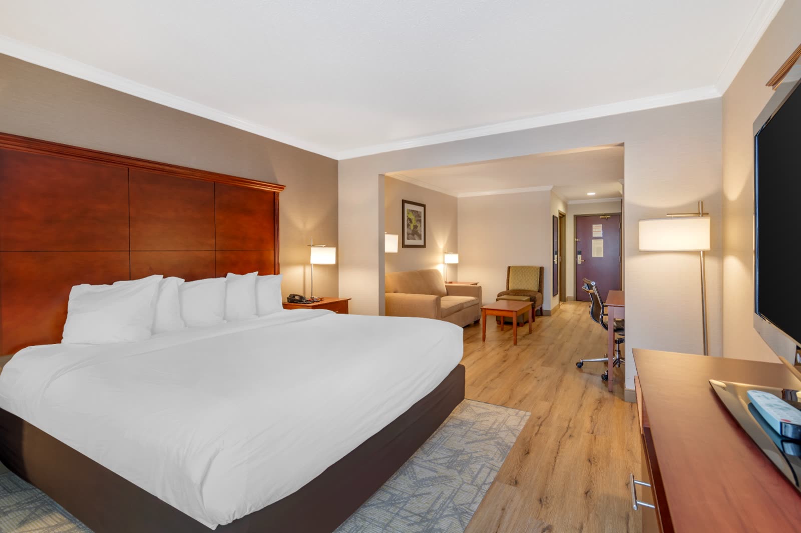 King Suite with king bed and separate sitting area at Syracuse Grand hotel