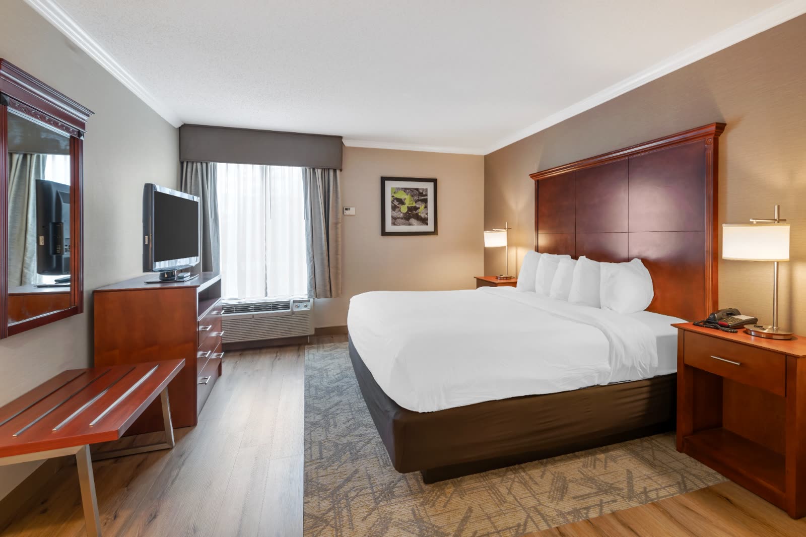 King guest room with king bed and work desk at Syracuse Grand hotel